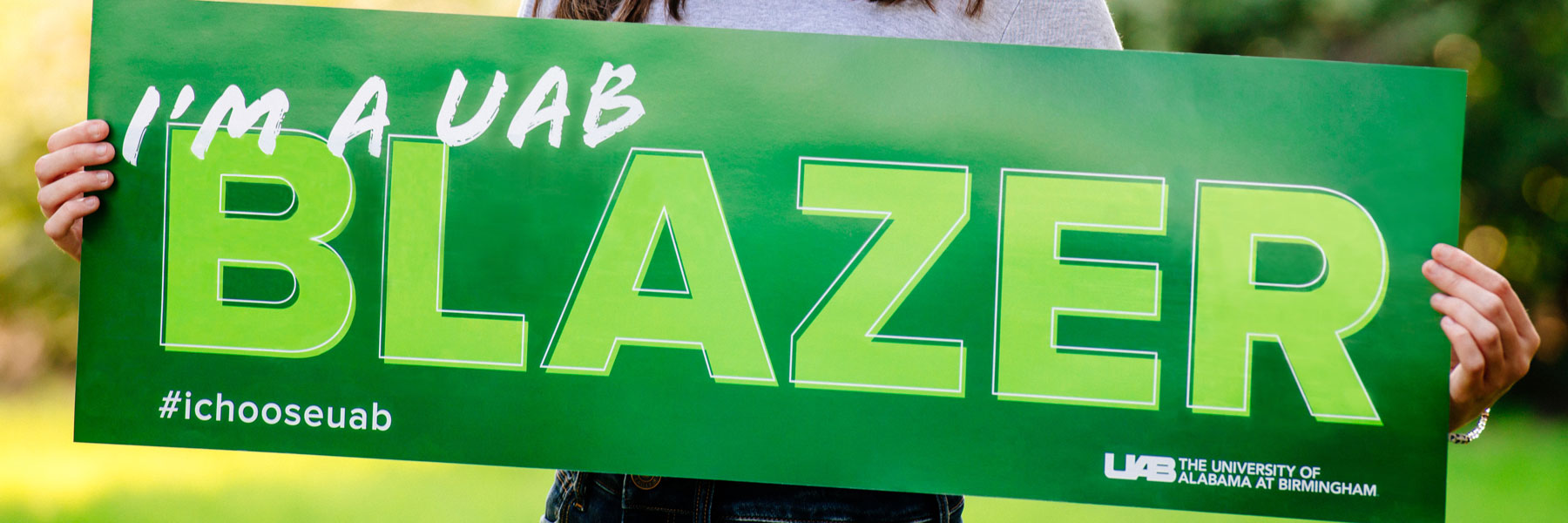 Student holding I'm a UAB Blazer sign