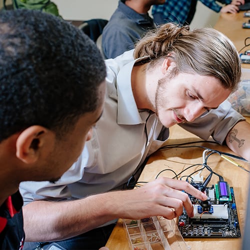 Two students working together on an engineering project.