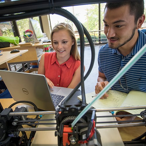 Two researchers examining equipment in the lab.