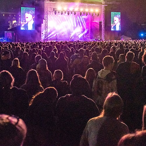 Crowd watching musicians playing on a stage.