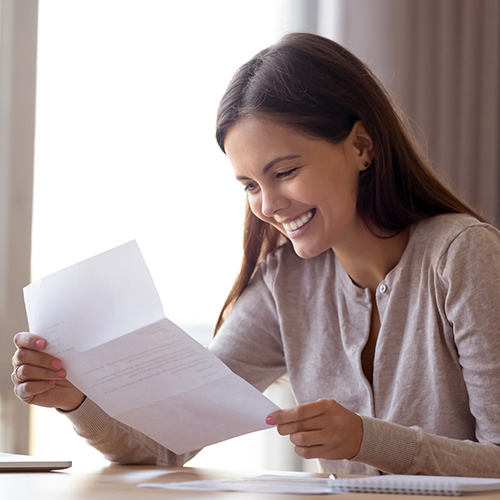 Smiling woman holding letter.