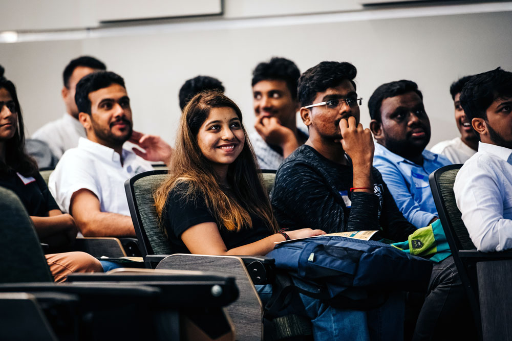 Into UAB students at orientation, sitting and smiling in classroom. 