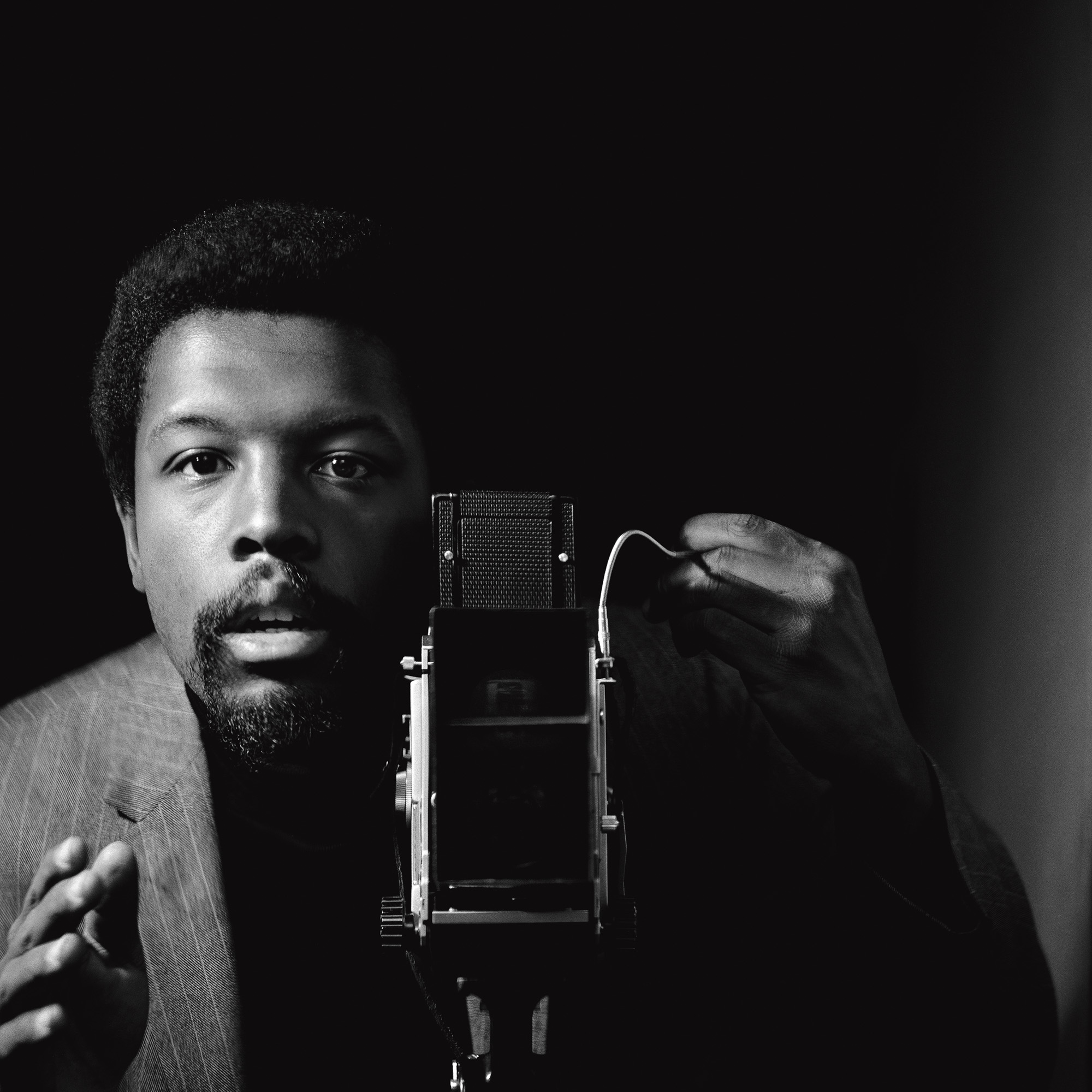 Black and white image of Kwame Brathwaite at antique camera. 