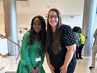 Professor Alicia McCall smiling with a student in a green dress