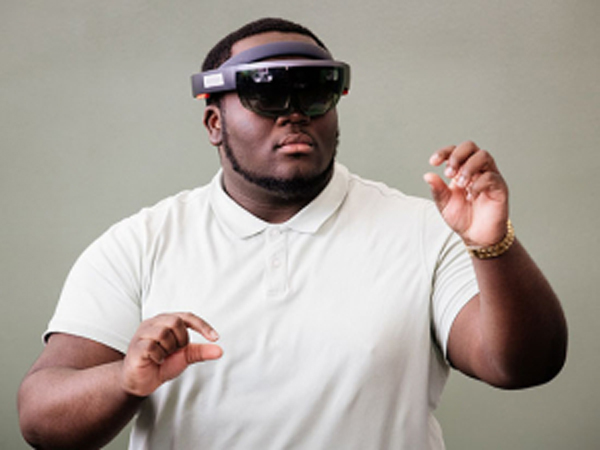 Student in a white shirt looking through a virtual reality headset 