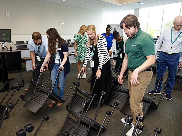 Individuals maneuver upside down desk chairs