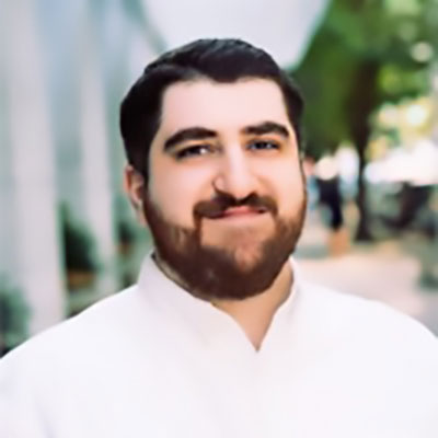 close photo of a man with dark hair and a beard 