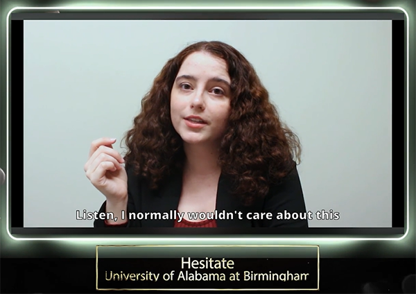 video still shot of a female student with long, curly brown hair talking to the camera