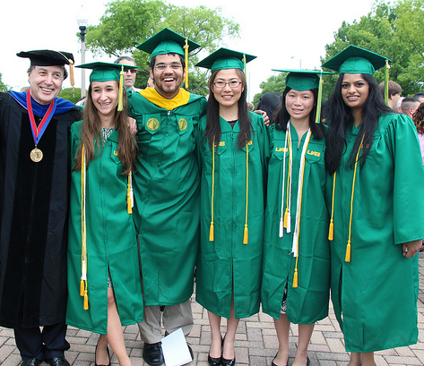 Students after graduation ceremonies, wearing caps and gowns. 