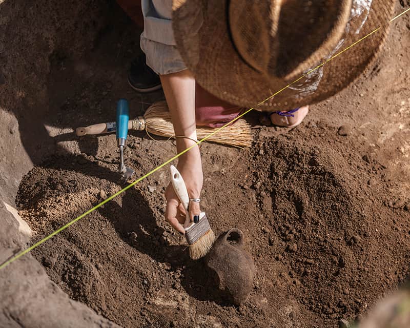 Anthropologist digging on site