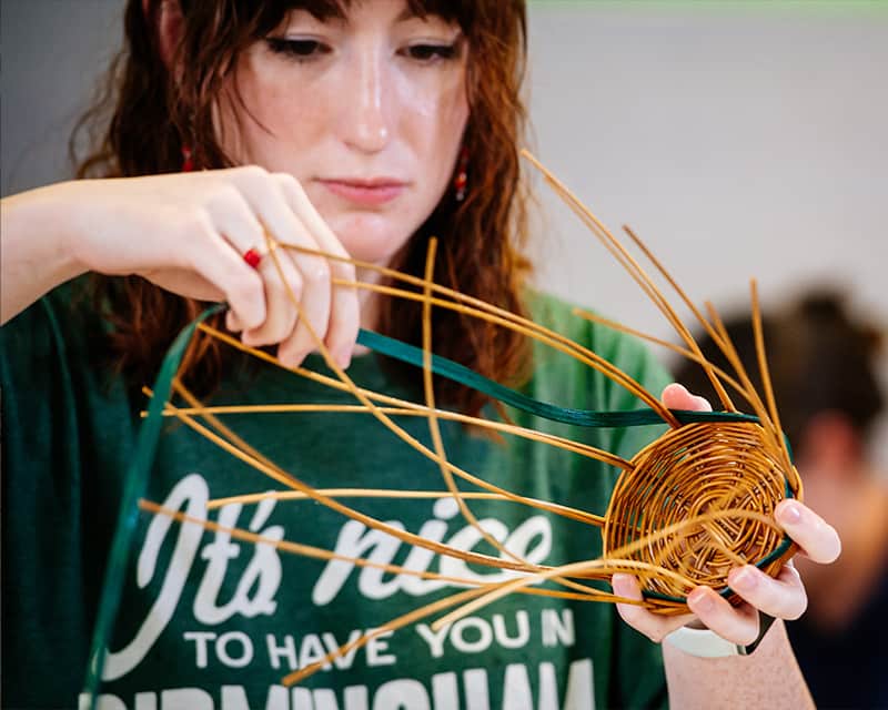 Student weaving a basket