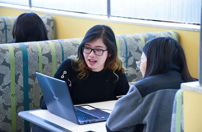Students sharing a laptop computer. 