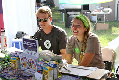 Brian Rice, left, sits with another volunteer at an Oxfam outreach table at this year's Bonnaroo Music and Arts Festival in Tennessee. 