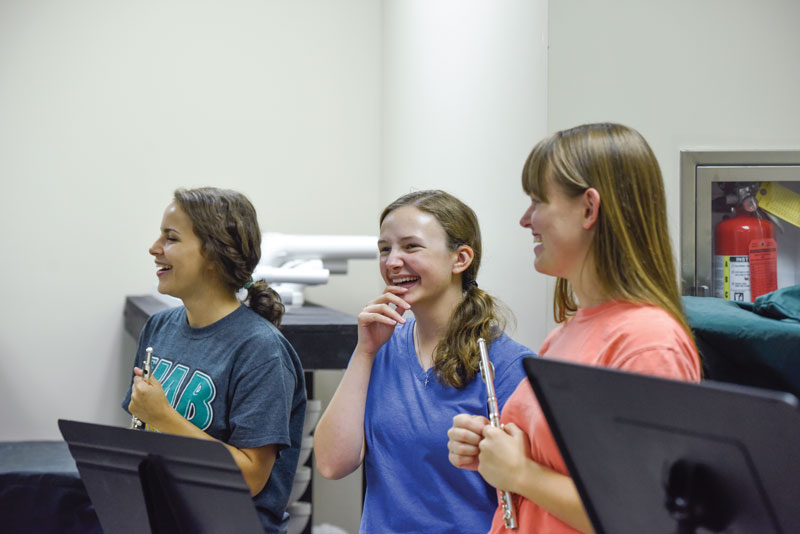 A trio of female flute players at band camp.
