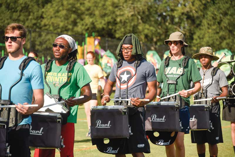 Drummers practicing on the field at band camp.