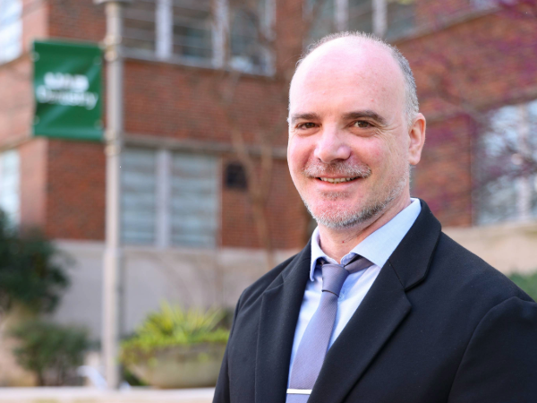 Ardenghi smiling in front of UAB School of Dentistry