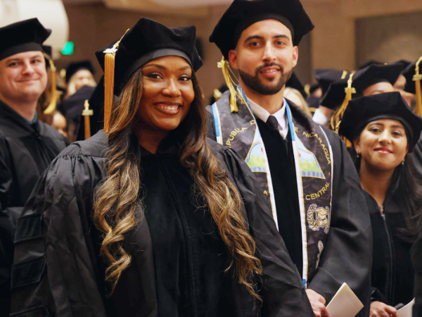 Four graduating dental students among their peers smiling at the 2025 SOD Commencement ceremony
