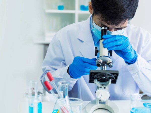 AdobeStock_1691460789 image depicting scientist/man looking through microscope and conducting research in science laboratory. 