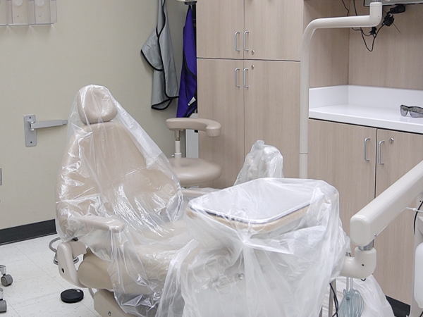 A photo one of the dental chairs in the UAB Civitan Sparks Dental Clinic. Clinic chair, cabinets, and xray equipment are seen in the background.