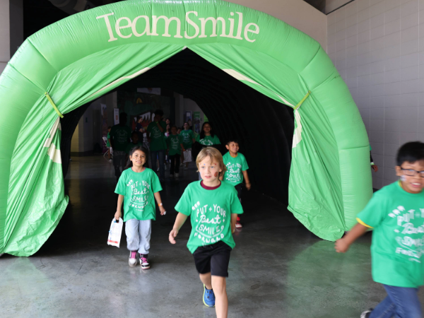 UAB and Teamsmile photo preview of kids running through tunnel