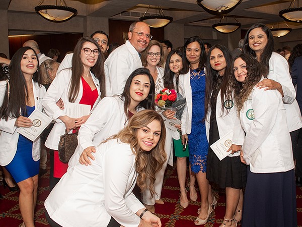 idp white coat - Dr. Stephen and Sonya Mitchell pictured center