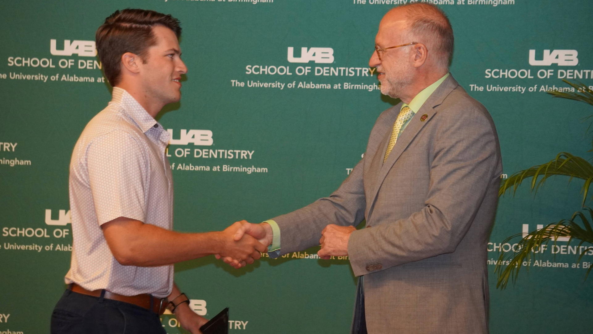 Dental Student and Dean Geurs shaking hands while recieving award during 2024 Honors Convocation