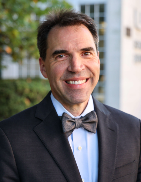 Man smiling in suit and bowtie in outdoor setting