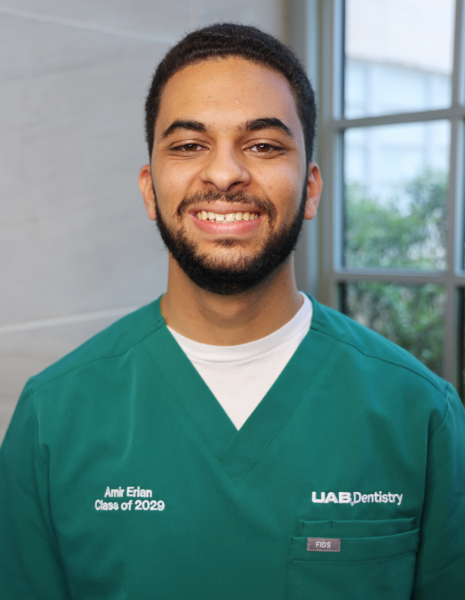 Smiling young man in green scrubs