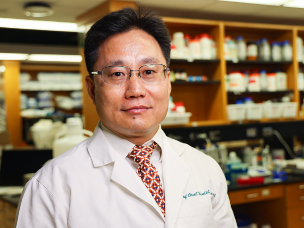 Man in white coat in lab setting