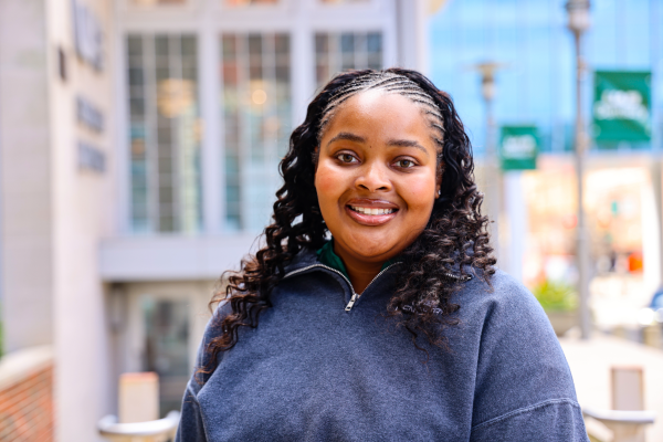 Young woman smiling in front of the UAB School of Dentistry