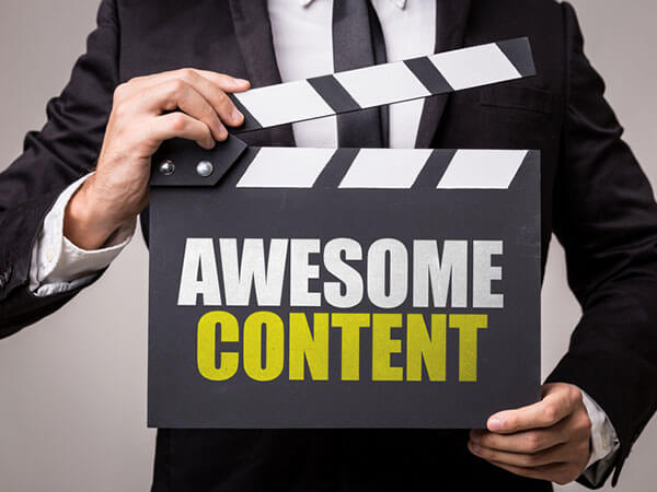 Man holding a movie clapboard that reads "Awesome Content."