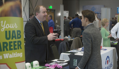 A student visiting a table at an Engineering job fair at UAB. 