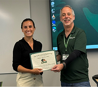 Paula Pino presented a certificate and plaque by Dean Jeff Holmes