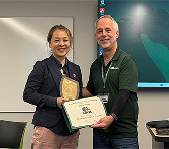 Yajing Wang presented a certificate and plaque by Dean Jeff Holmes