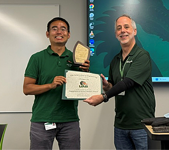 Chengyi Xu presented a certificate and plaque by Dean Jeff Holmes
