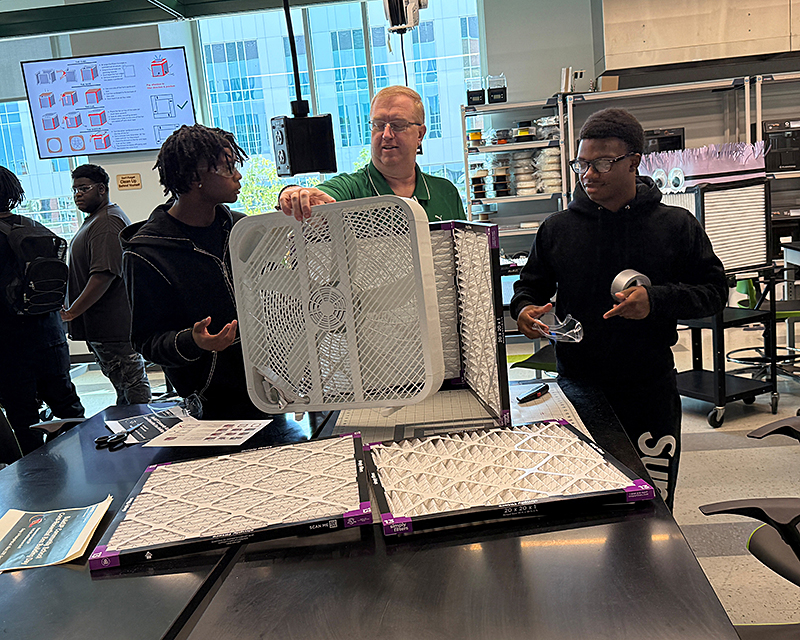 A professor building device with students 