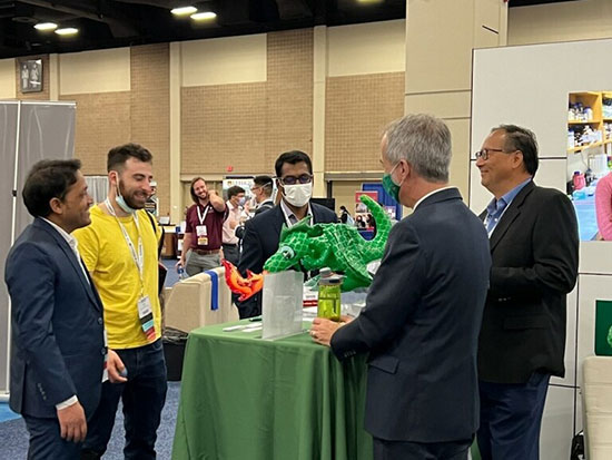 5 men, including faculty, gathered around a table at the UAB booth.