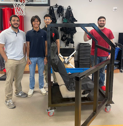 Students posing with assistive device