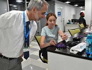 Dean Jeff Holmes and a student look at a drone