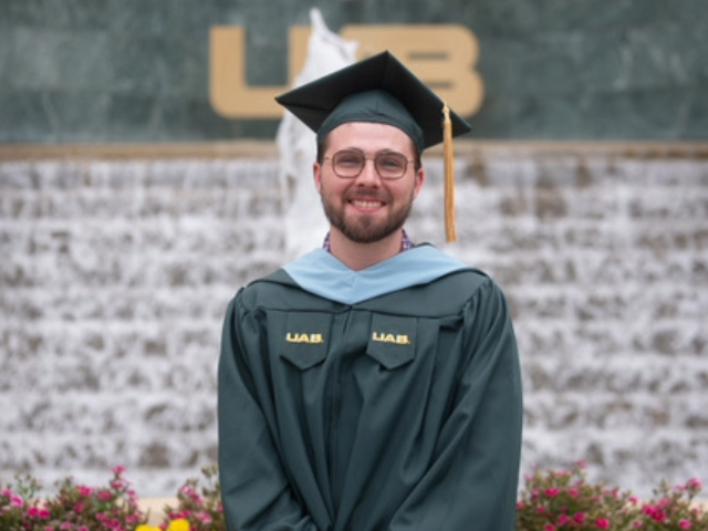 Photo of alum David Turner in front of the UAB water fountain.