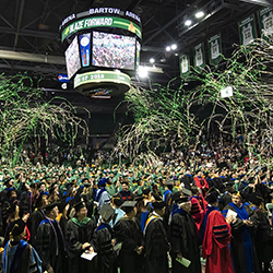 graduates celebrate under confettii in Bartow Arena.