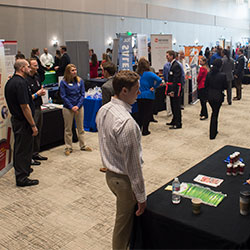 Students milling around tables at a recruitment fair.