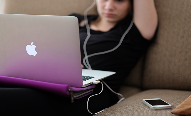 Girl sitting on couch with a laptop