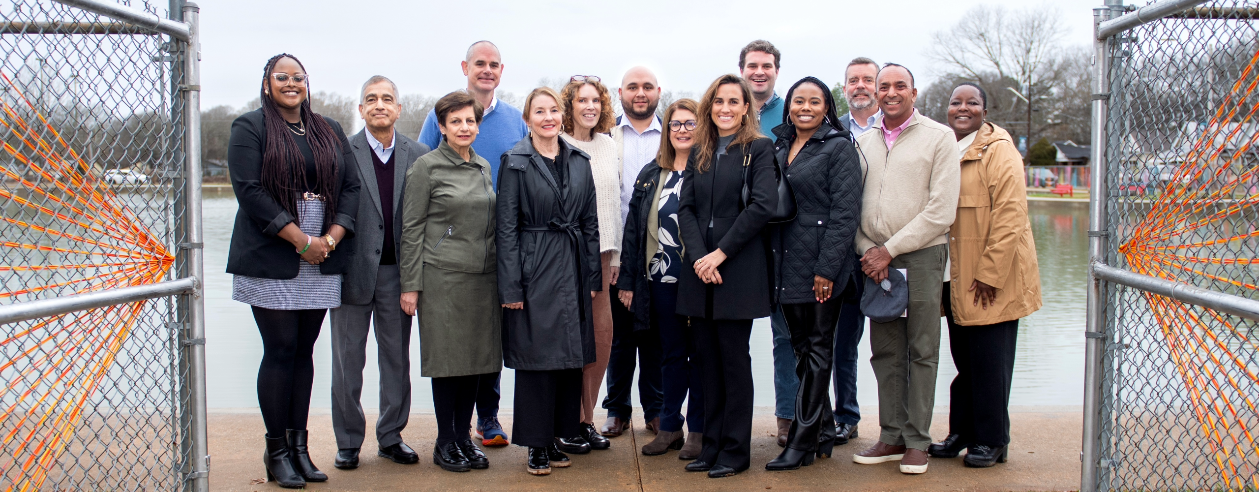 Three Black women wearing Bush Hills neighborhood shirts in front of a Live HealthSmart banner. 