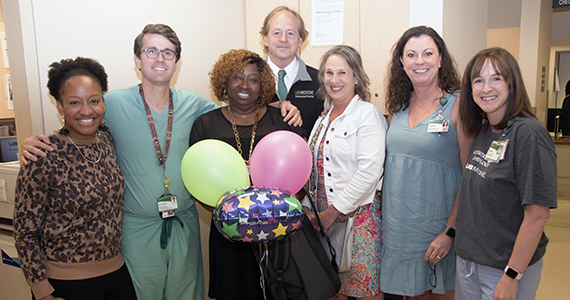 DOM STAR Awardee, Sharon Harris and co-workers smile in celebration of her recognition