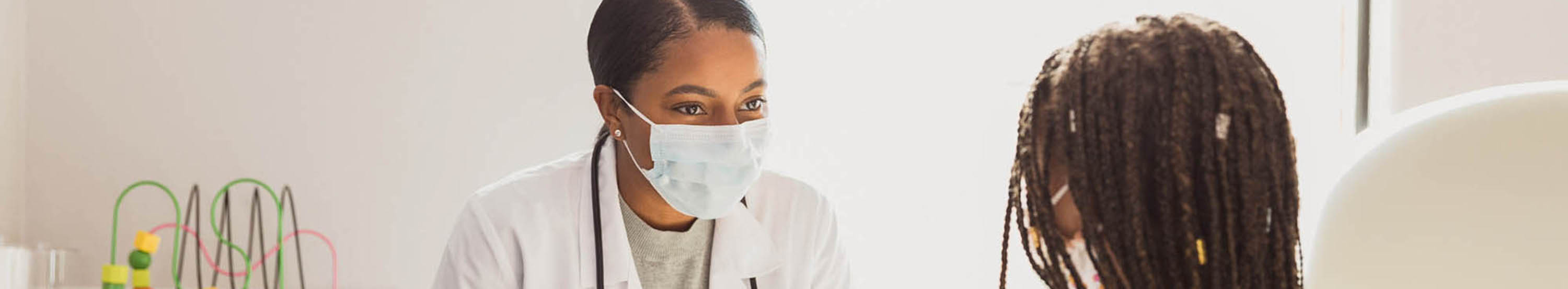 A healthcare provider listening to a small child. 