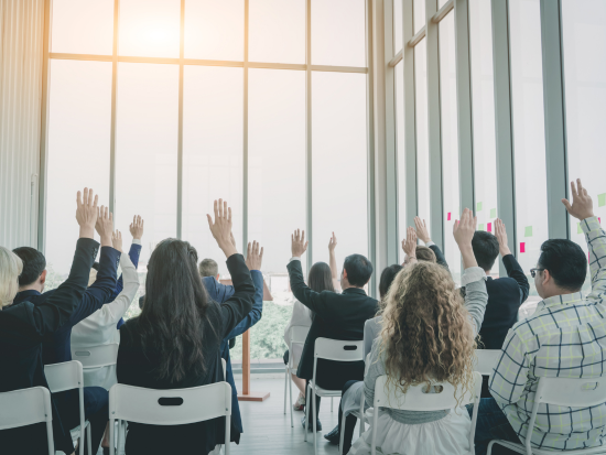 Group of business persons raising their hands