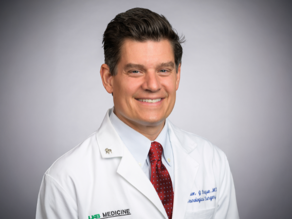 Professional man wearing white doctor's coat and red tie.