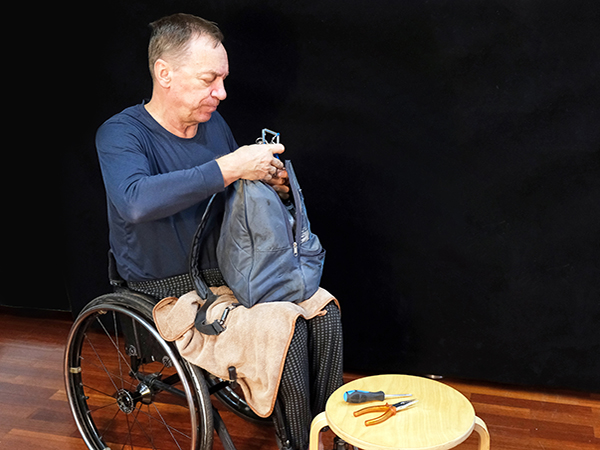 Man packs tools and essentials in an emergency backpack. 