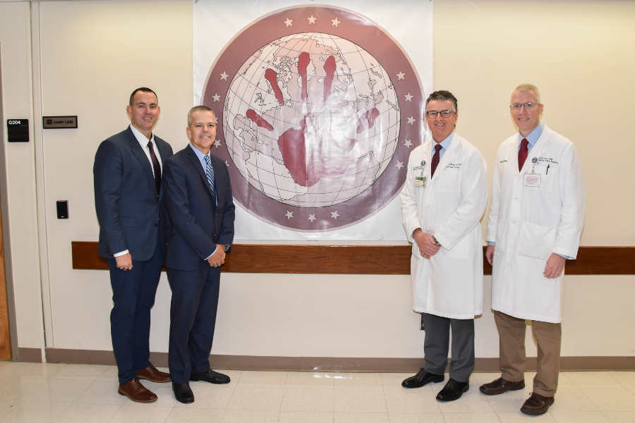 Left to right: Chief Master Sgt. James Woods, Lt. Gen. John DeGoes, Dr. Jeffrey Kerby, and Dr. Daniel Cox outside the SOST office at UAB Hospital.